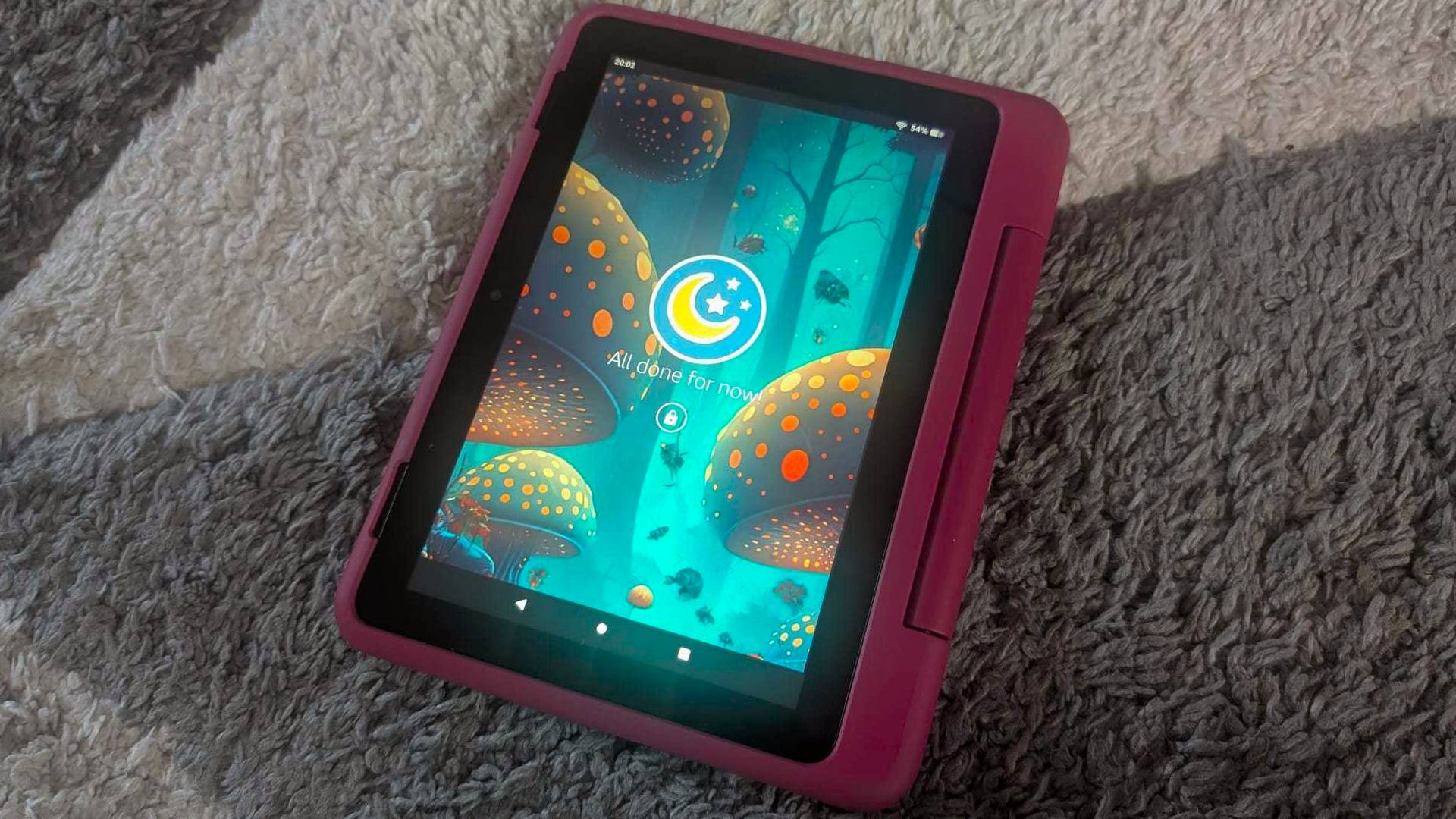 Fire HD 8 Kids Pro tablet on grey carpet with lock screen displayed.