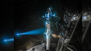 A silver stainless-steel SpaceX Starship is assembled for launch on the pad for Flight 7.