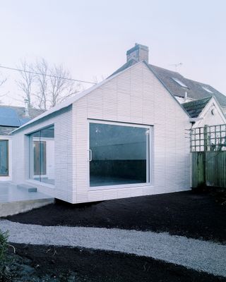 white brick clad cantilever extension to building