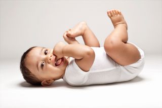 A baby modelling against a white studio background