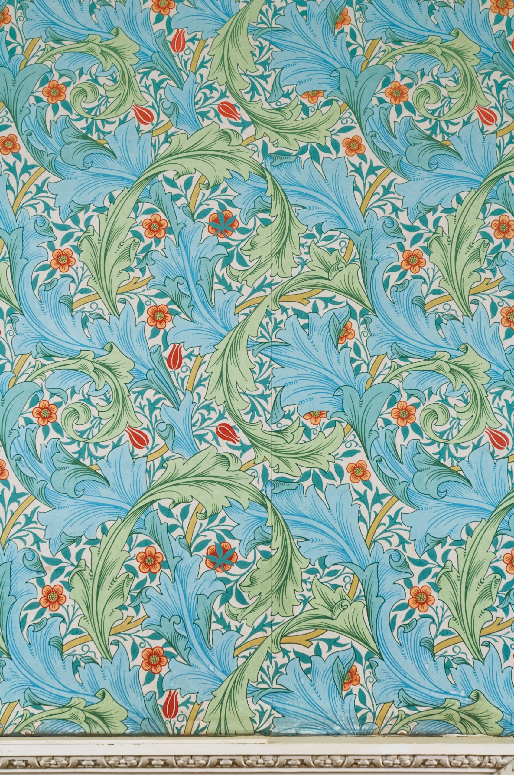 A close-up of blue, green and orange, leaf-motif wallpaper