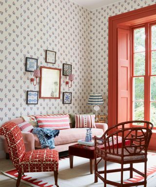 A living room with Dado's daydress wallpeper, red curtains and a red couch