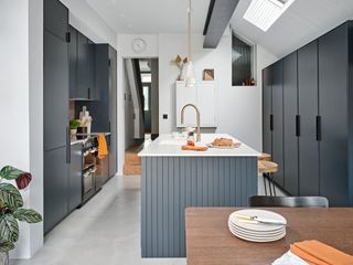 Extended kitchen with dark grey units, white worktop and rooflights