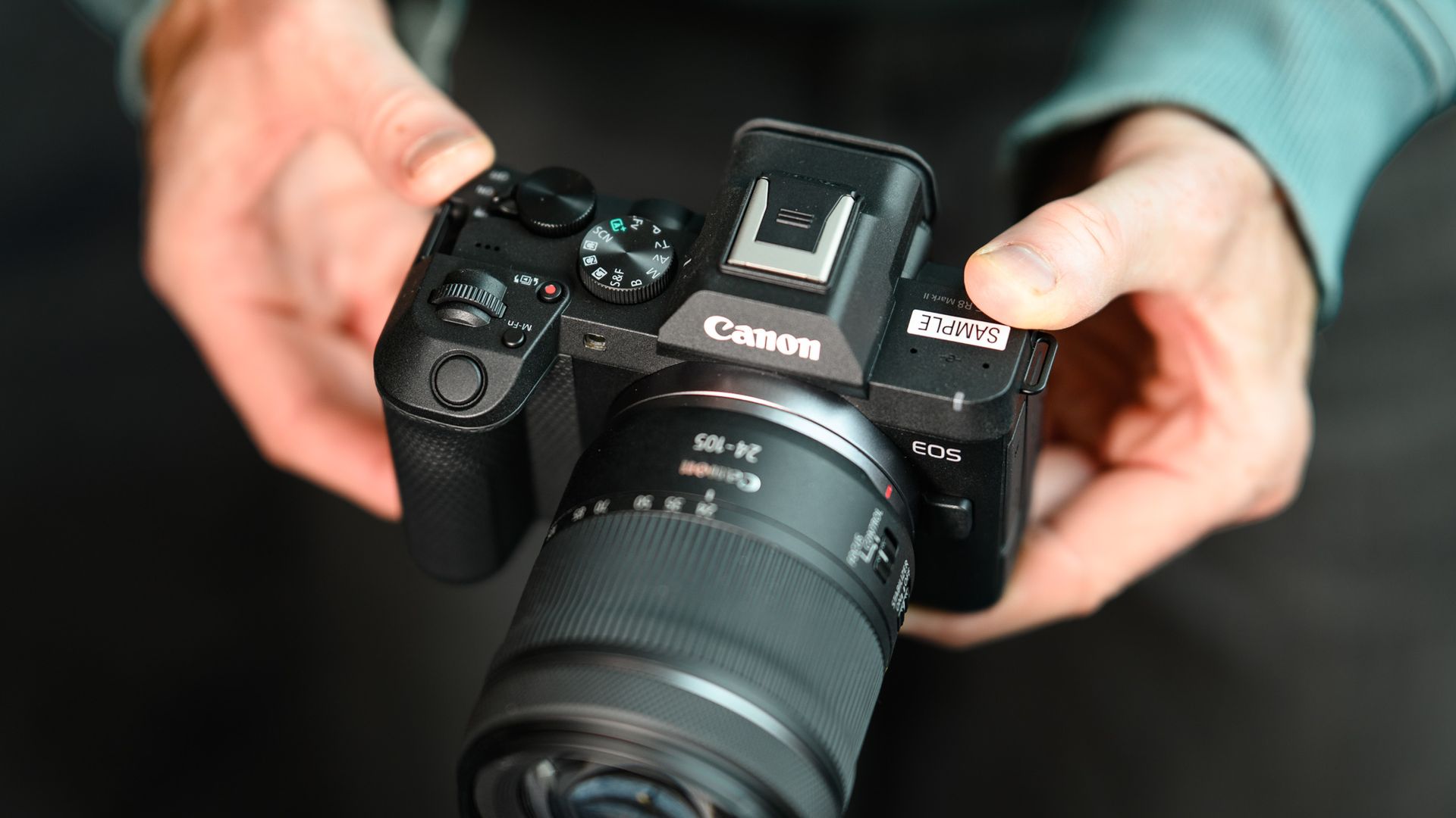 Top of the Canon EOS R8 Mark II, in user's hands, 24-105mm lens attached
