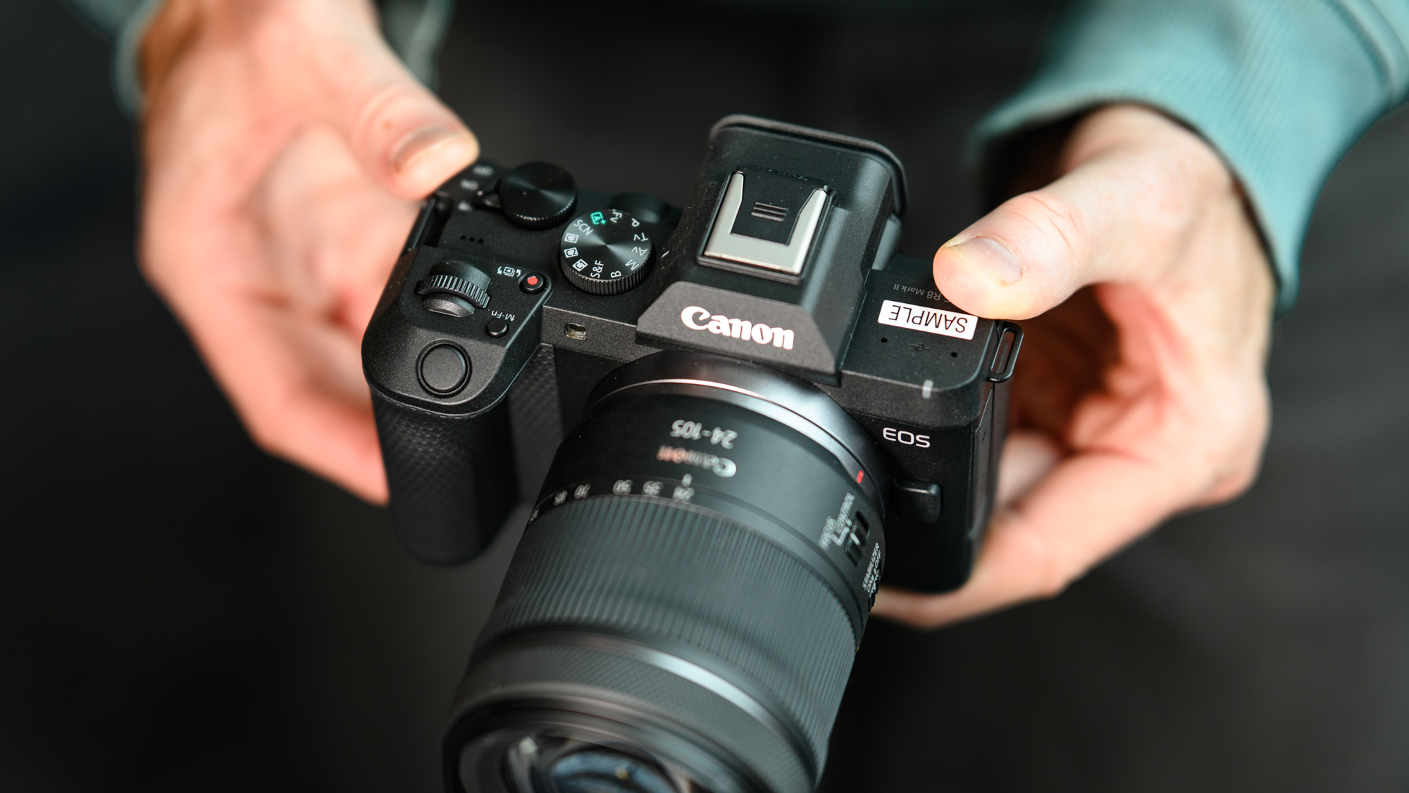 Top of the Canon EOS R8 Mark II, in user's hands, 24-105mm lens attached