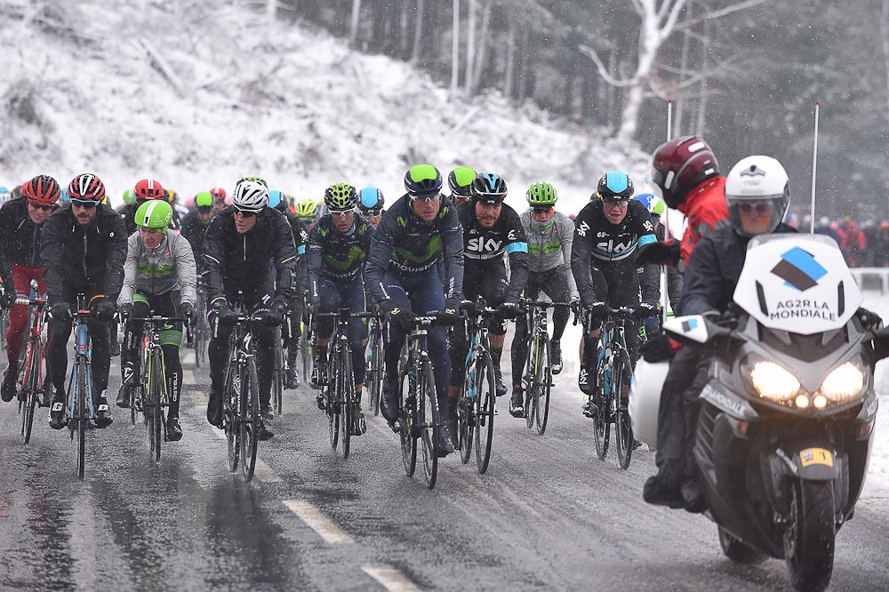 The peloton rides together as the snow falls on Paris-Nice.