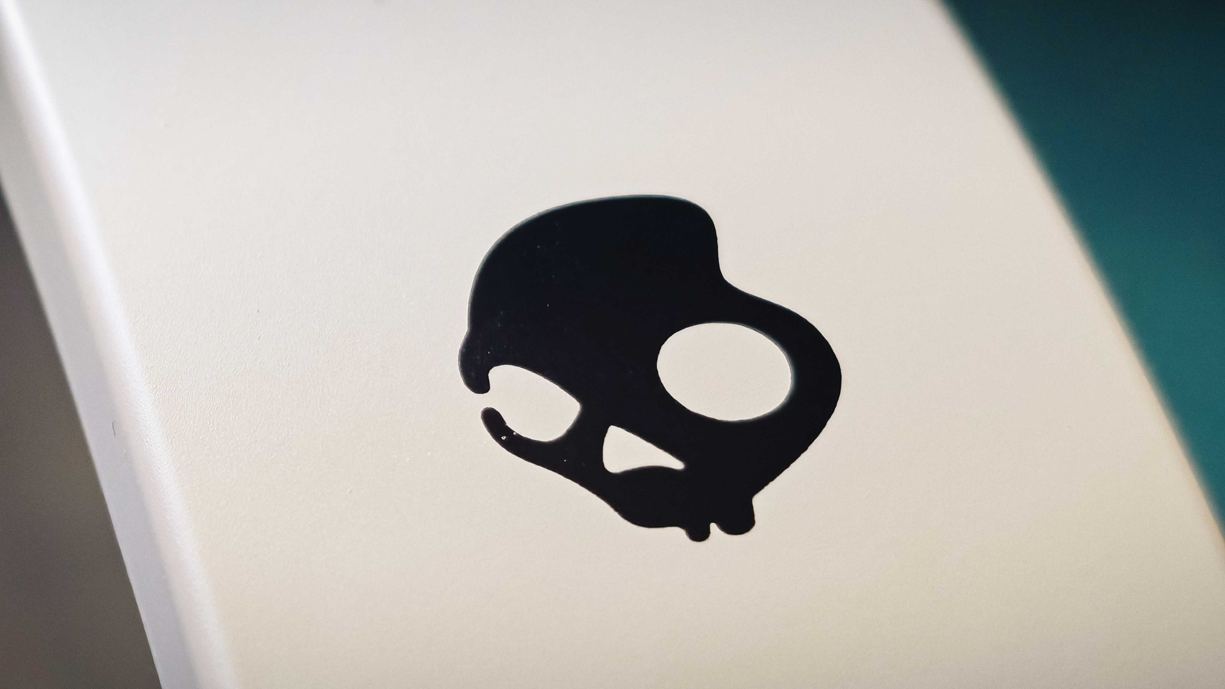 A white pair of Skullcandy Crusher 540 Active headphones on a green sofa