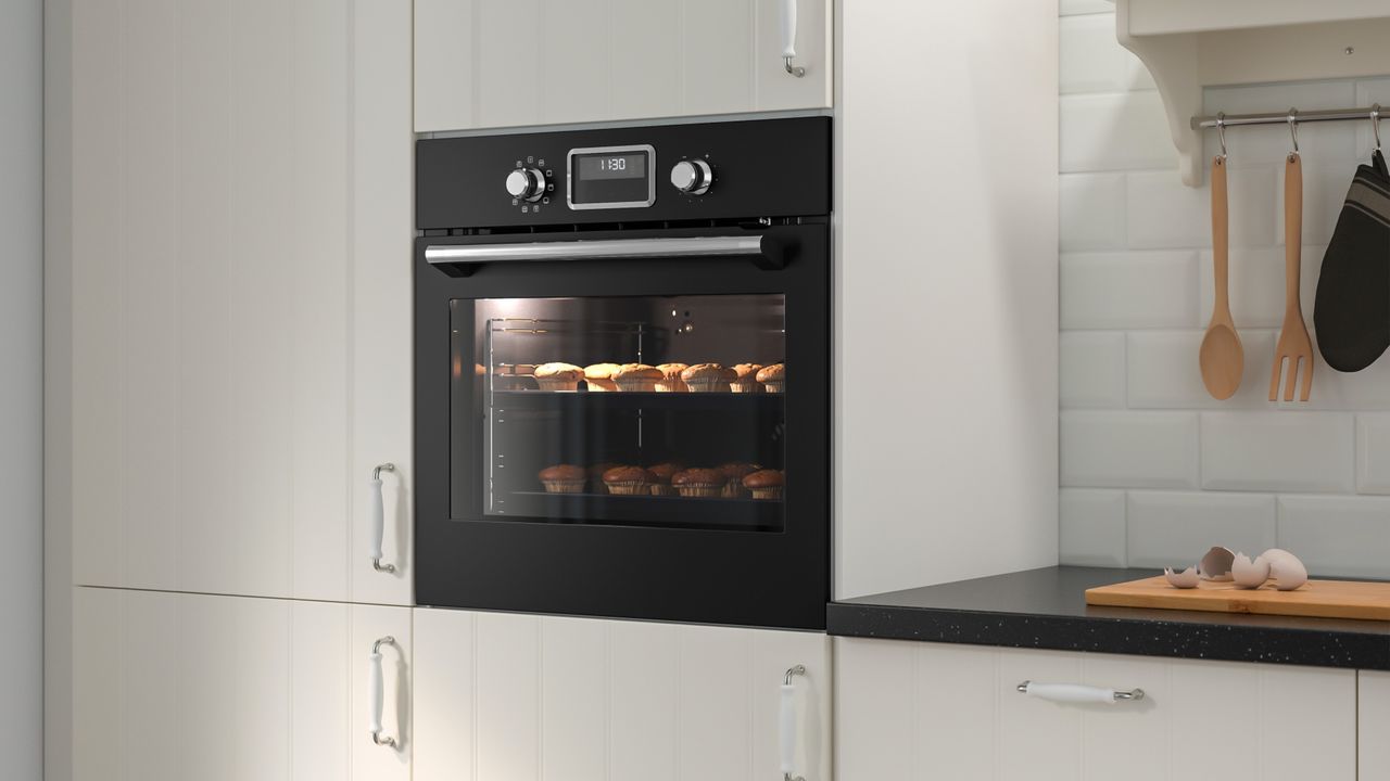 IKEA black oven installed in white kitchen storage units