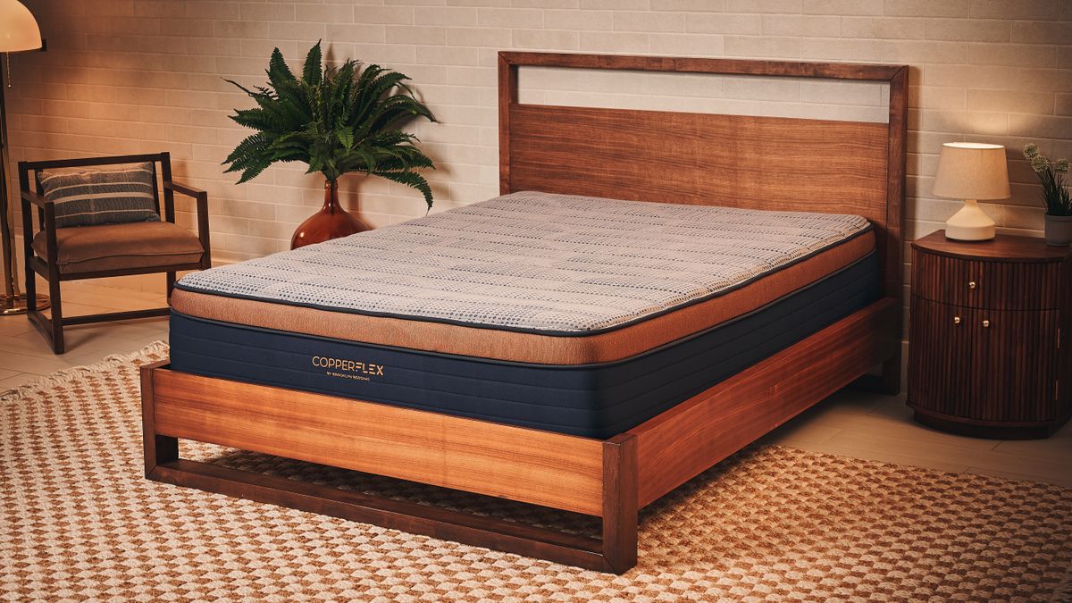 Grey, navy and bronze Brooklyn Bedding Copperflex Memory Foam Mattress on wooden bed frame in sleep studio