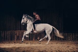 A black man riding a white horse