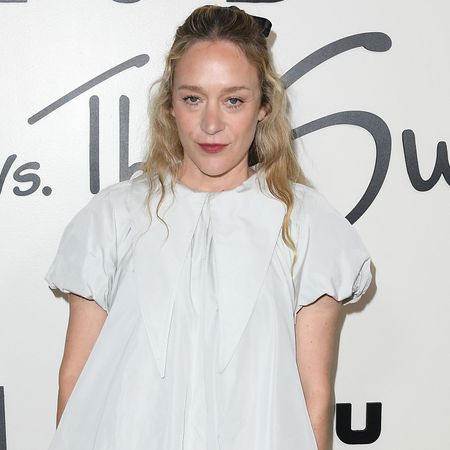 Chloe Sevigny wears a white dress and a black hair ribbon