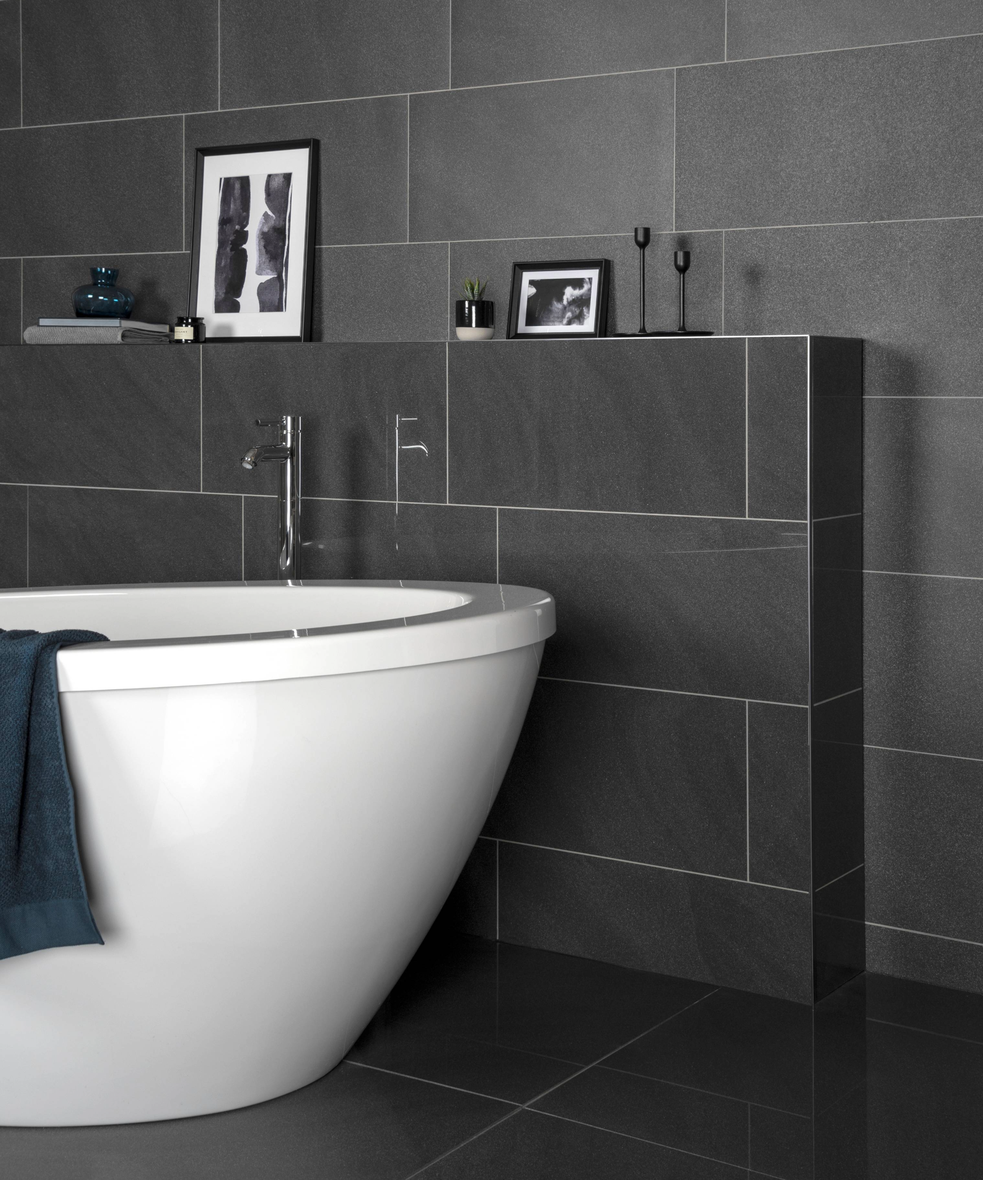 Tiling idea for small bathroom with black large tiles against a white freestanding bath