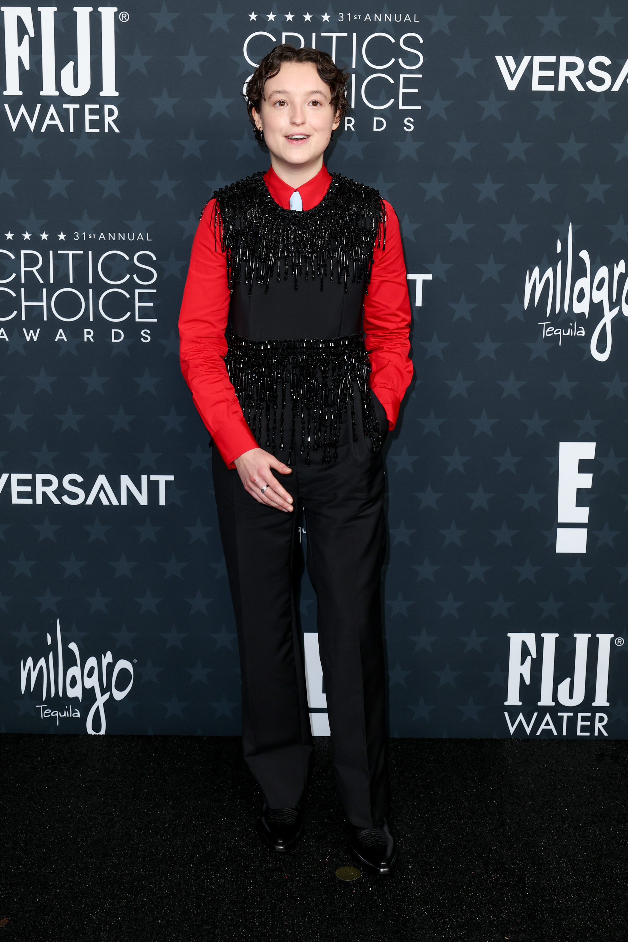 Bella Ramsey at the 2026 critics choice awards wearing a black fringe suit with beading