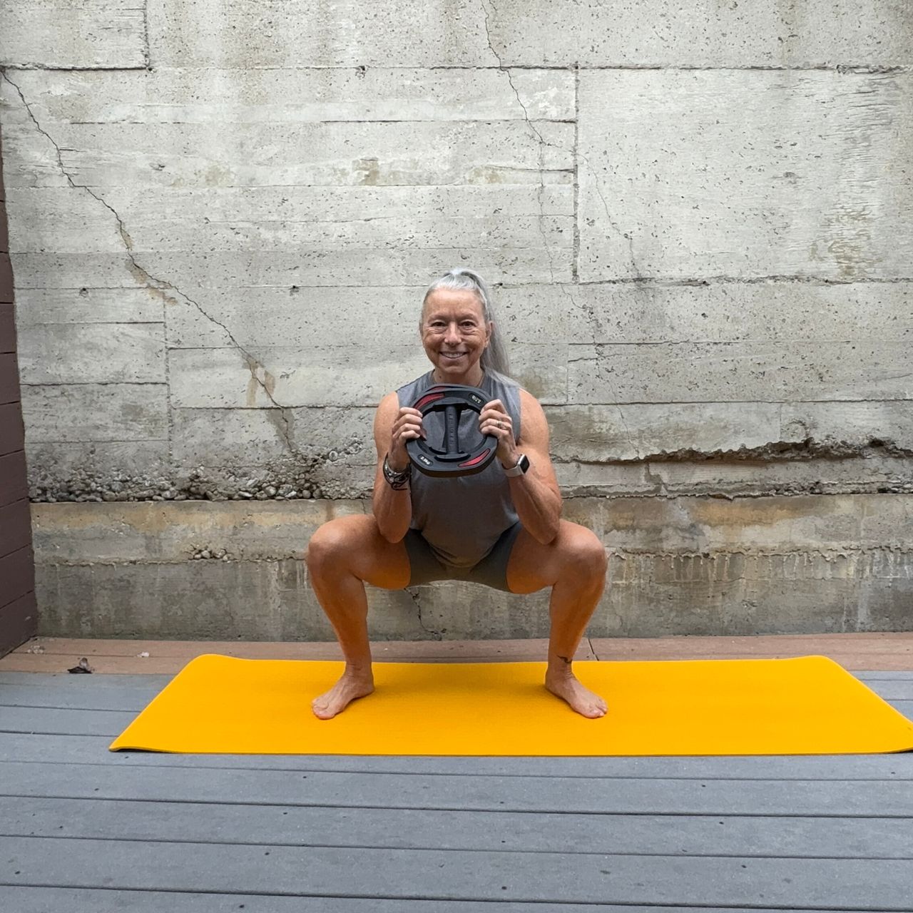 Woman exercising with weight plate