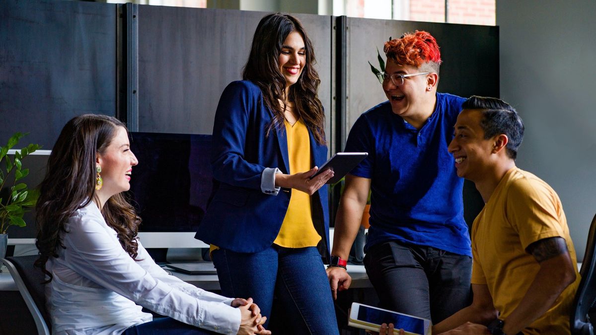 Group of young people in office gathered around one of the best iPad alternatives 