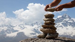 Man building rock cairn