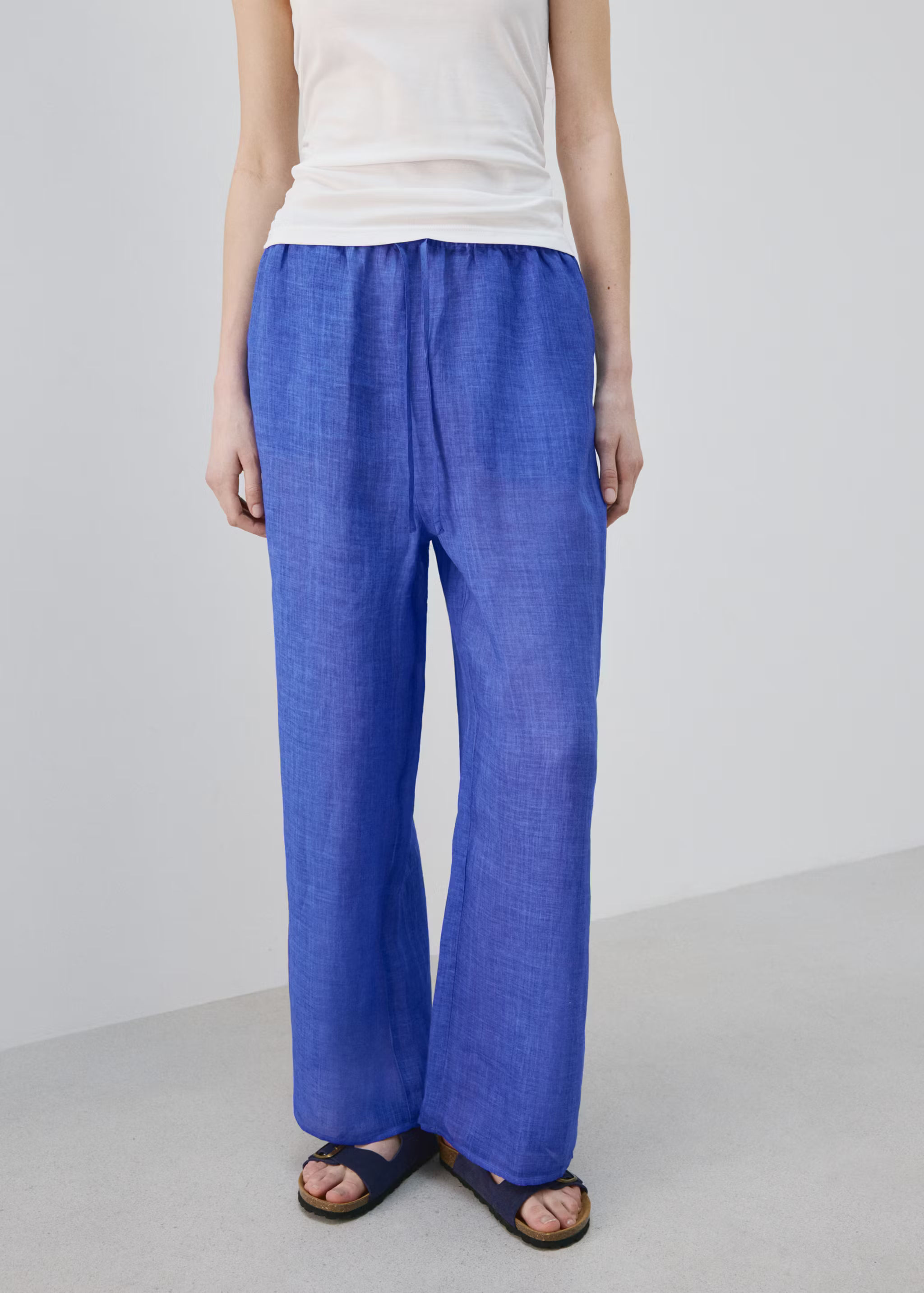 A model wearing cobalt Mango trousers.