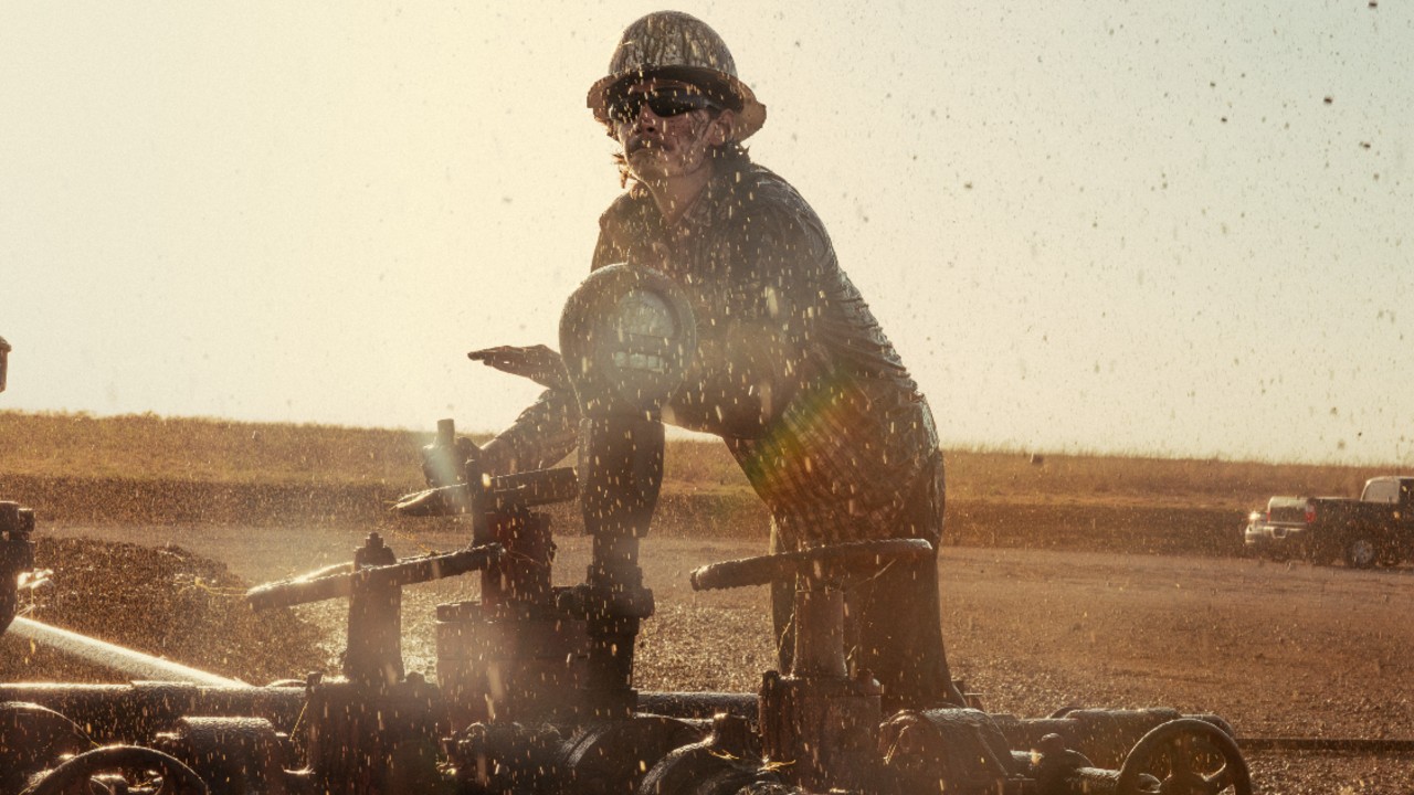 Jacob Lofland as Cooper Norris standing behind oil that is flying up in the air.