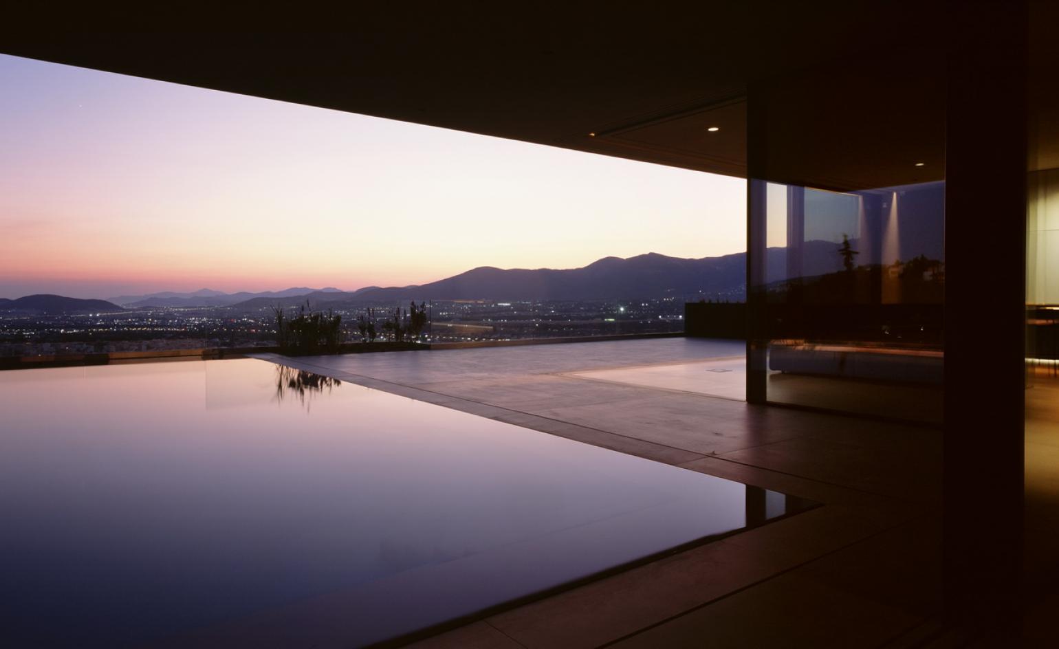 Swimming pool at dusk in reflection house in Athens