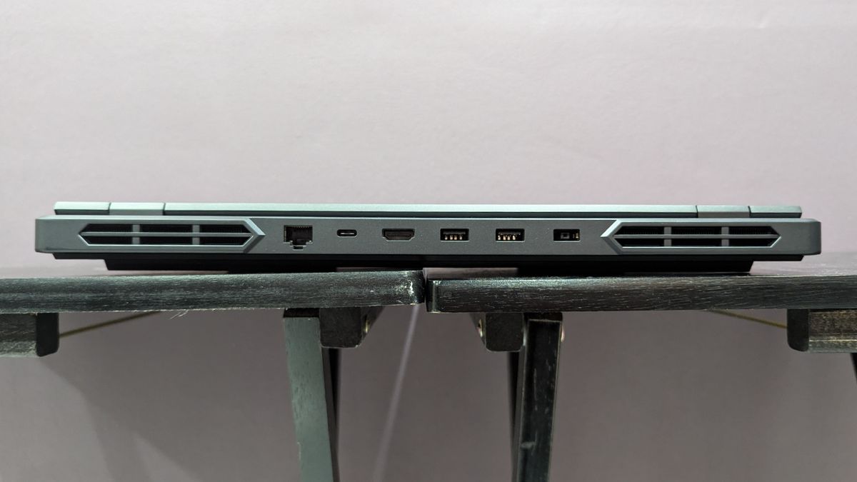 Lenovo Legion Pro 5i closed on a black desk, highlighting the back ports, including power jack, two USB Type-A, USB Type-C, HDMI, and Ethernet.