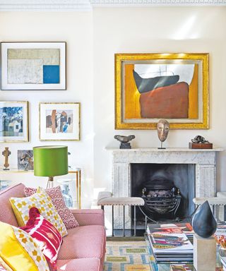 white living room with pink patterned couch and yellow cushions with marble fireplace