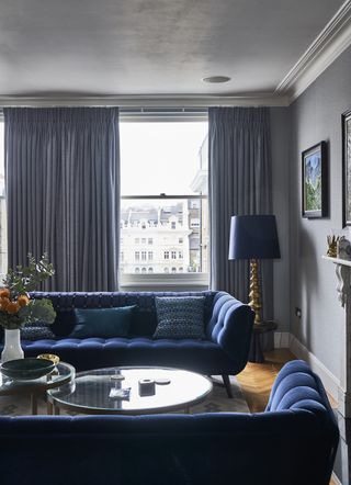 small living room with two blue buttoned sofas