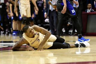 Trent Forrest of the Florida State Seminoles goes to the floor with a muscle spasm in his leg during a match-up with the Duke University Blue Devils on Jan. 12, 2019.