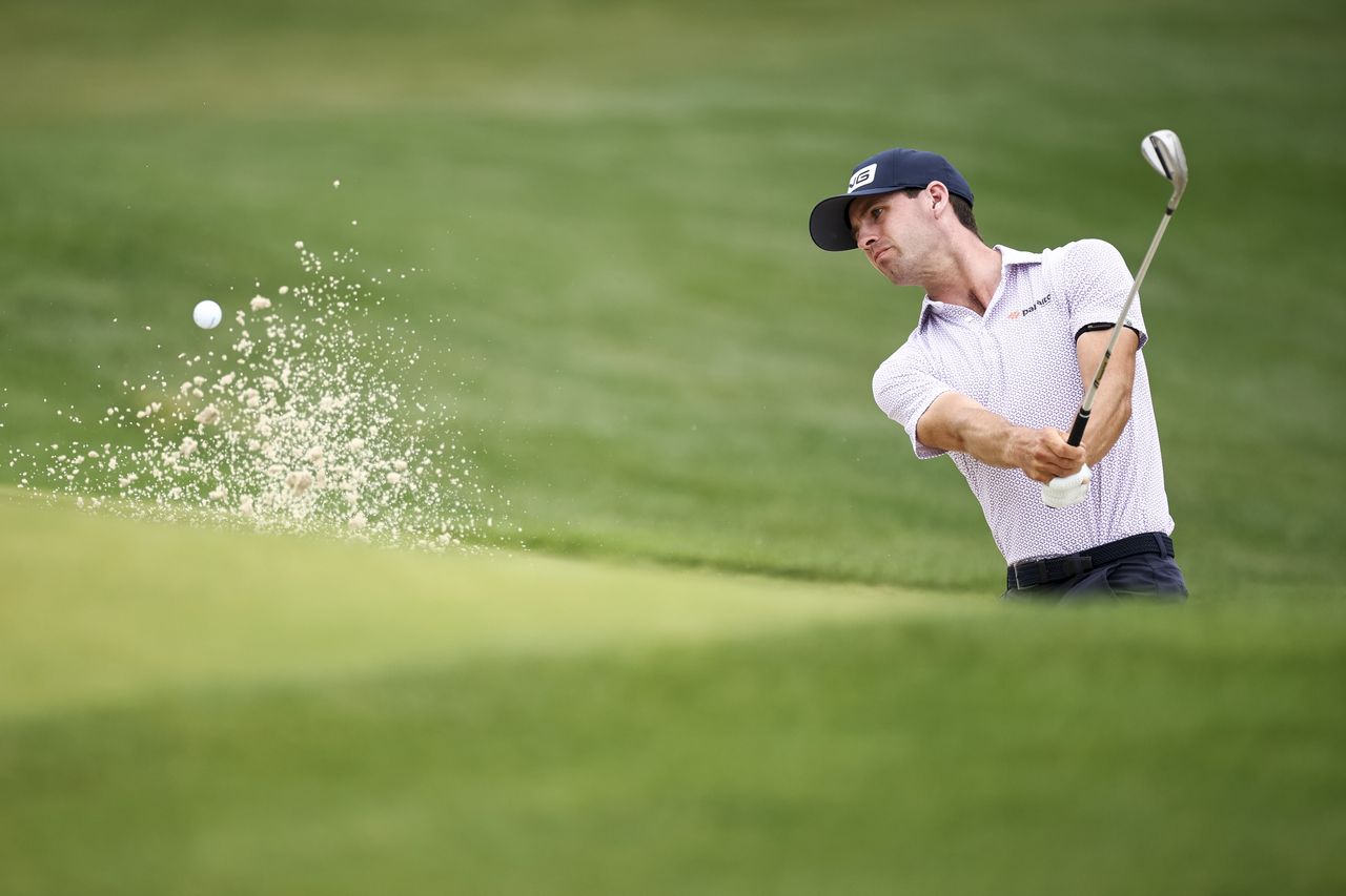 Alex Smalley hits out of a greenside bunker on the first hole during the first round of the Truist Championship at Quail Hollow Country Club
