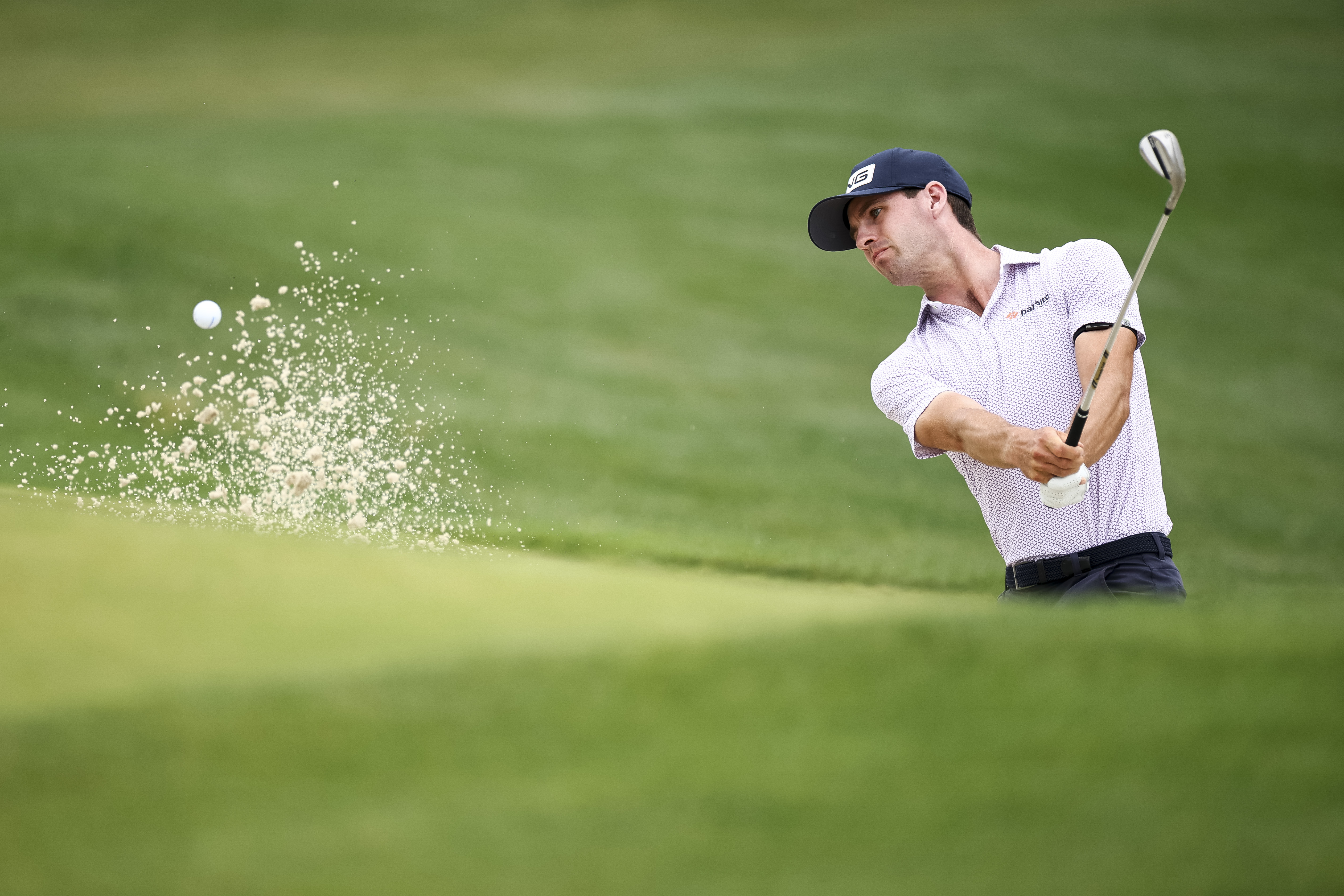 Alex Smalley hits out of a greenside bunker on the first hole during the first round of the Truist Championship at Quail Hollow Country Club