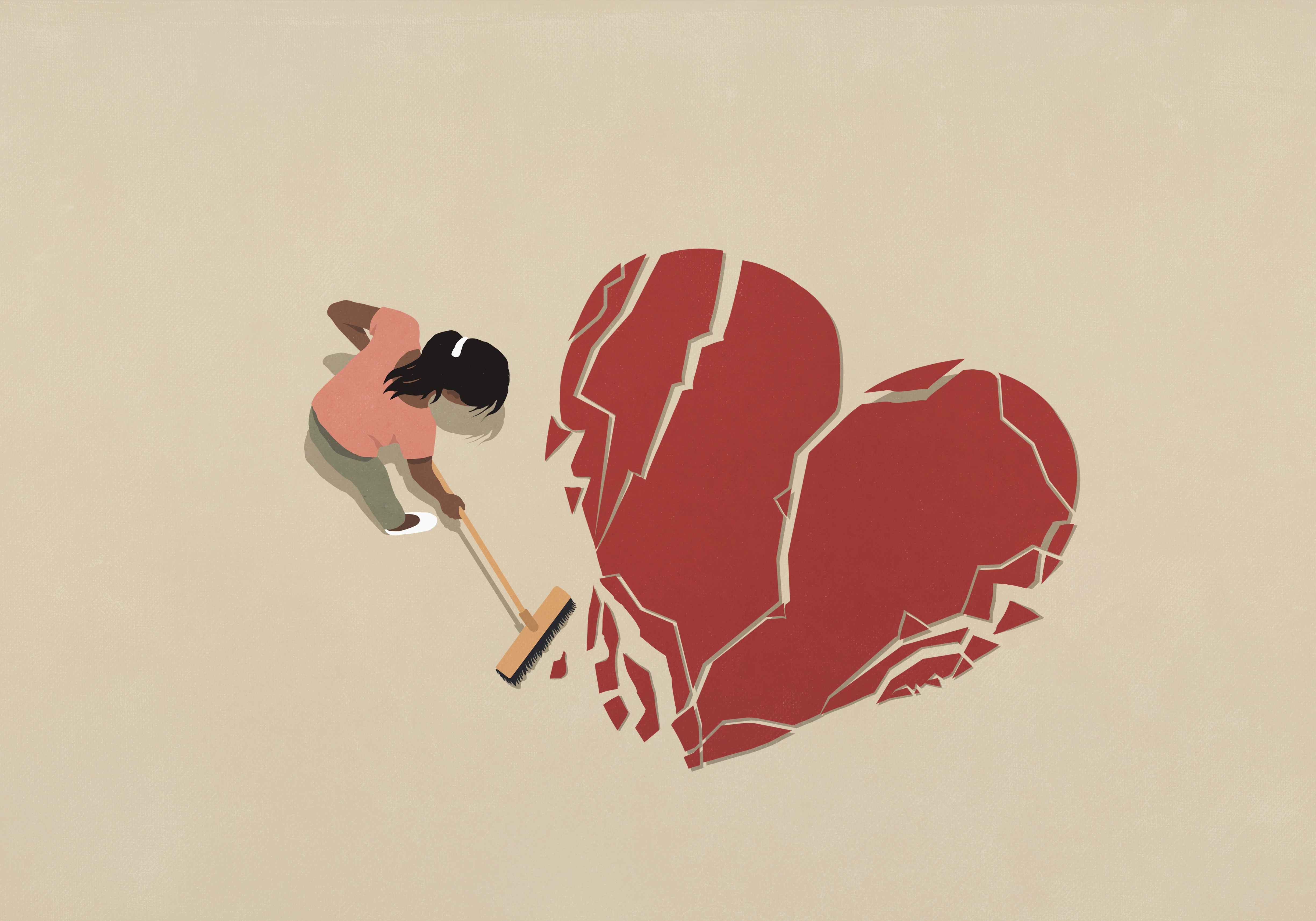 View from above woman with broom sweeping broken heart