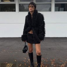 An image of @endlesslyloveclub wearing one of the best black boots with a chic winter jacket. 