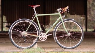 A sid eon view of a pale green steel bike