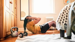 Man doing a six-pack home workout in his bedroom