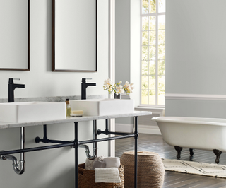 a bathroom with crisp white walls and twin sinks with matt black taps