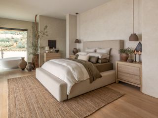 A neutral decorated bedroom with a large jute rug