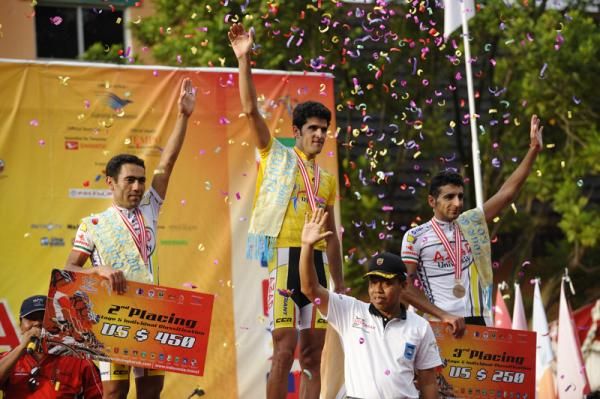 Stage winner standing between teammates on podium