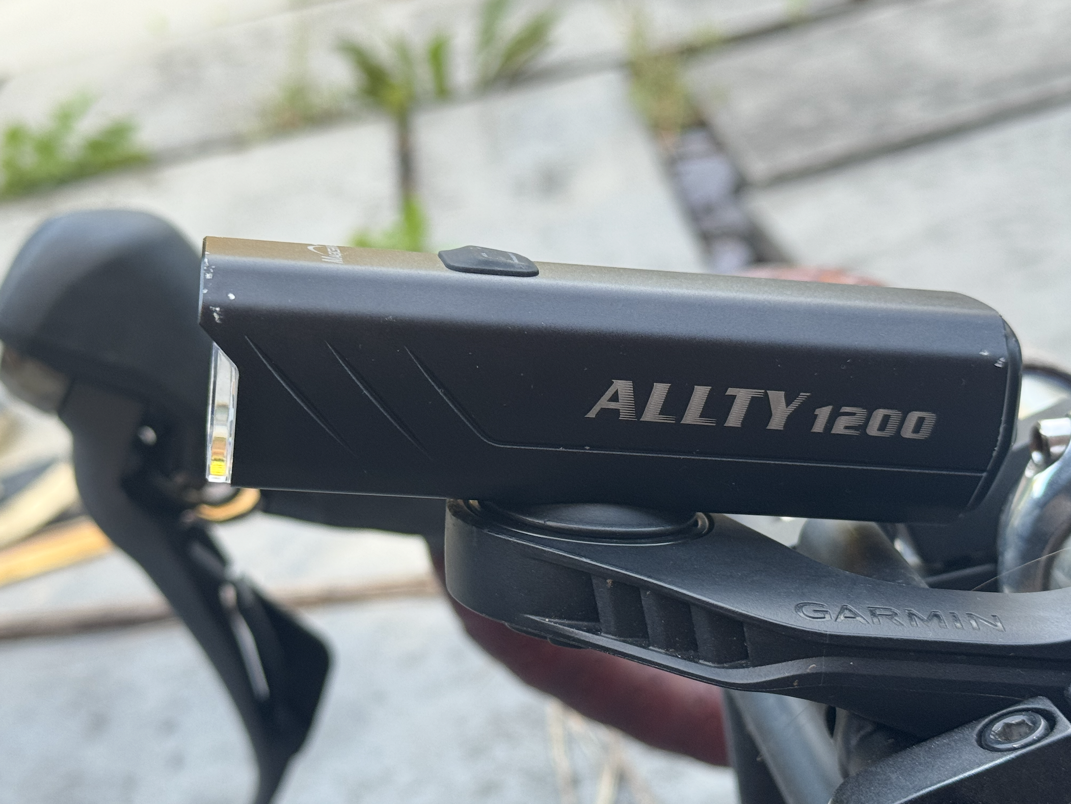 The MagicShine Allty 1200 sits on handlebars on a Garmin mount and out and front. You can see the small cut outs on the side of the light to widen the beam.