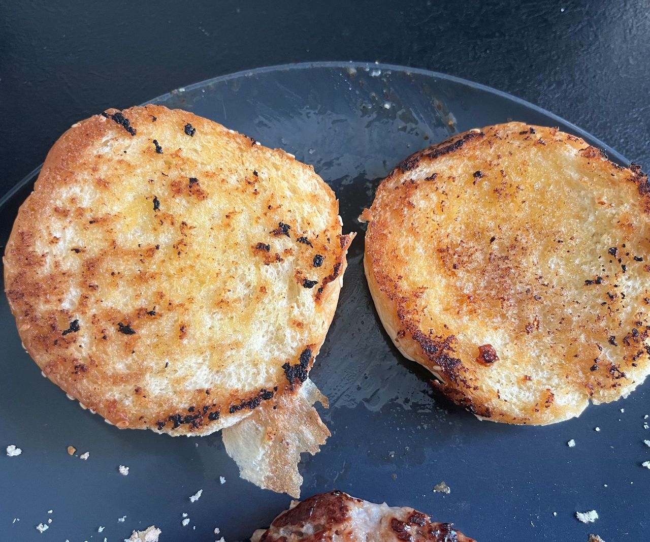 A toasted burger bun on a plate