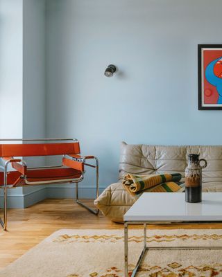 light blue living room with red and gray accent chairs