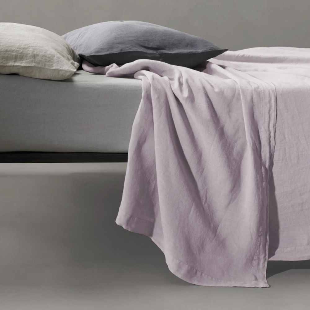 Bed made with lilac linen sheet