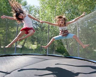 two children jumping on a trampoline