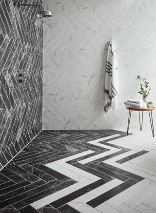 black and white bathroom tiles laid in a pattern in a small showerroom
