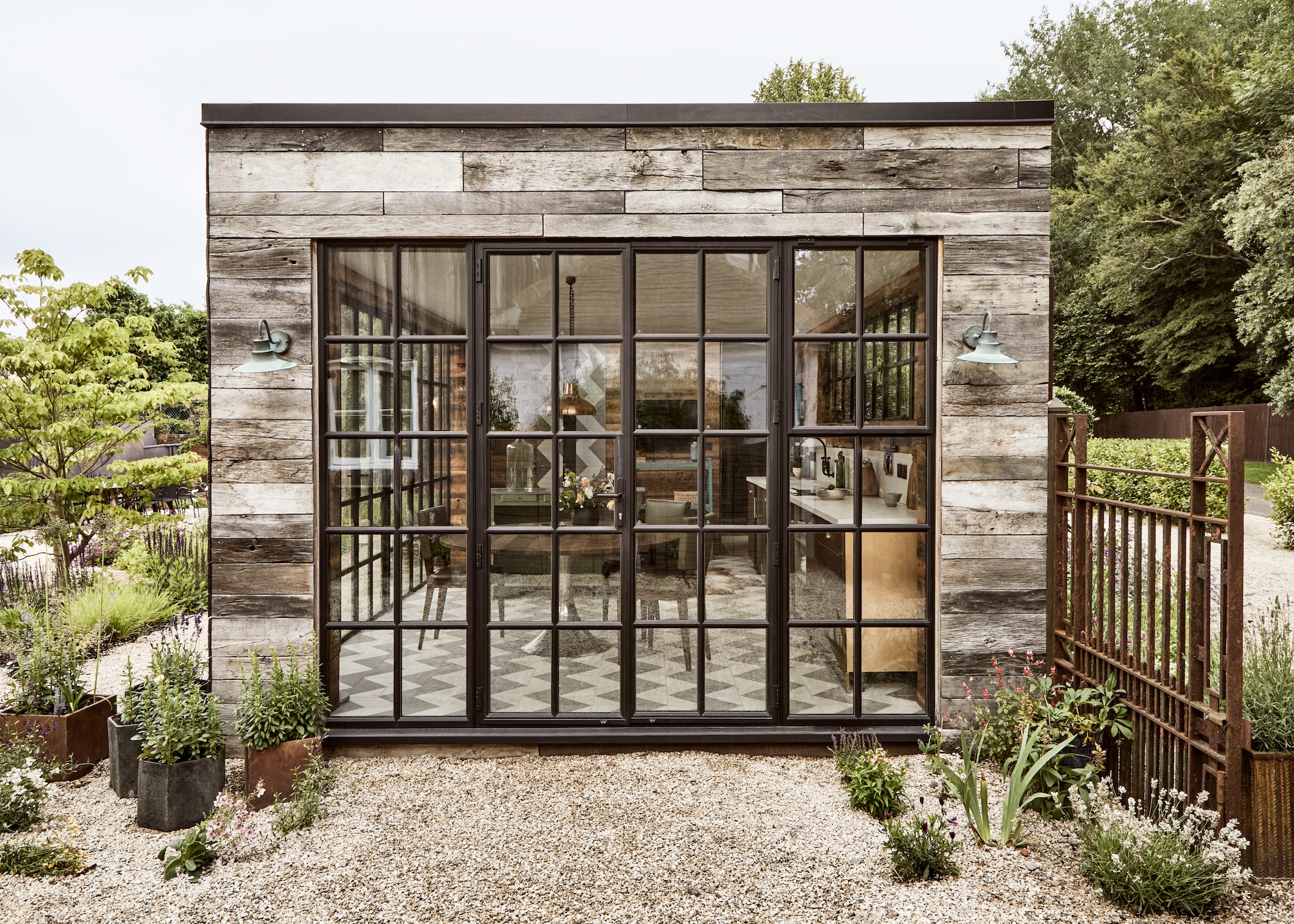 an outdoor contemporary cabin made from reclaimed materials with Crittall-style glazing