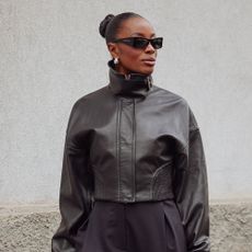 Woman wearing a leather coat, and sunglasses