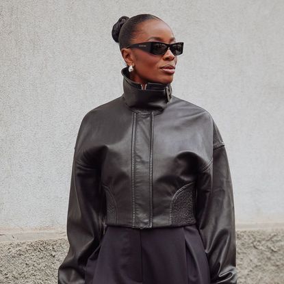 Woman wearing a leather coat, and sunglasses
