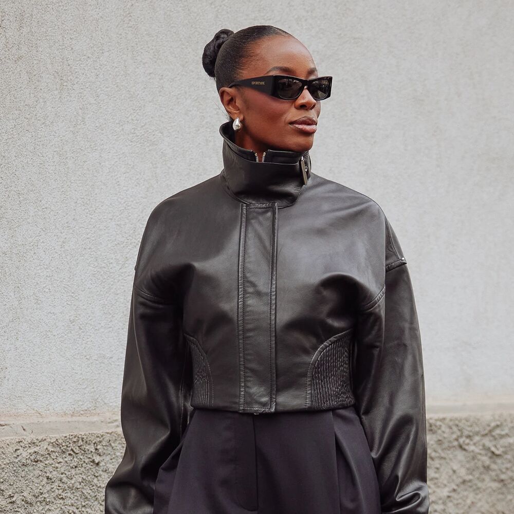 Woman wearing a leather coat, and sunglasses