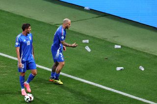 Federico Dimarco of Italy throws plastic beer cups off of the pitch during the UEFA EURO 2024 group stage match between Croatia and Italy at Football Stadium Leipzig on June 24, 2024 in Leipzig, Germany. 