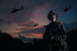 woman soldier looking victorious with apache helicopter fly past.