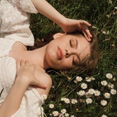 A woman lying in the grass considering beingi in an open relationship