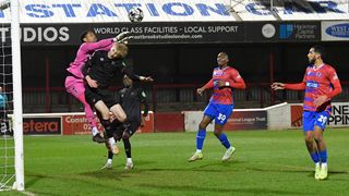 Airidas Golambeckis of West Ham United battles with Dagenham & Redbridge goalkeeper, Nathan Harvey during the National League Cup match between Dagenham & Redbridge and West Ham United U21's at Chigwell Construction Stadium